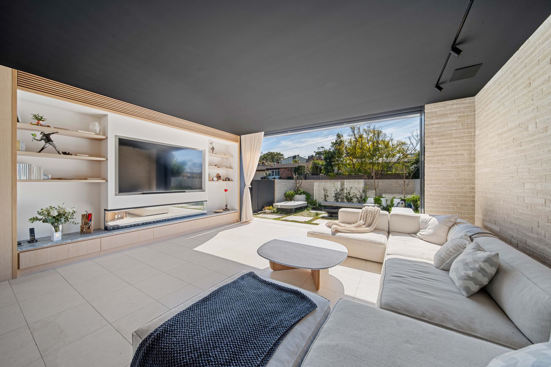 Living room with media wall opening to the garden