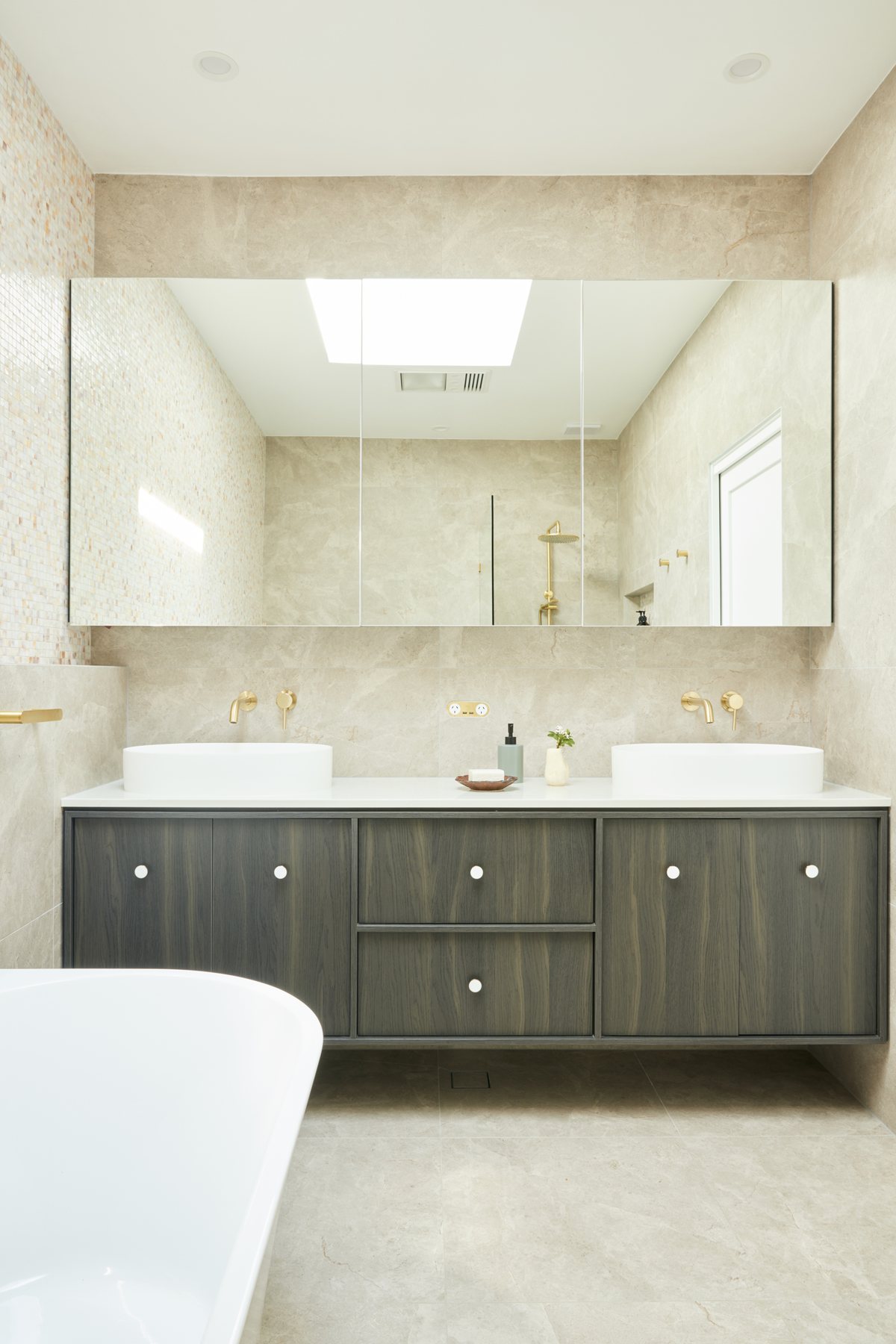 Bathroom with double vanity and a brass power outlet between the basins