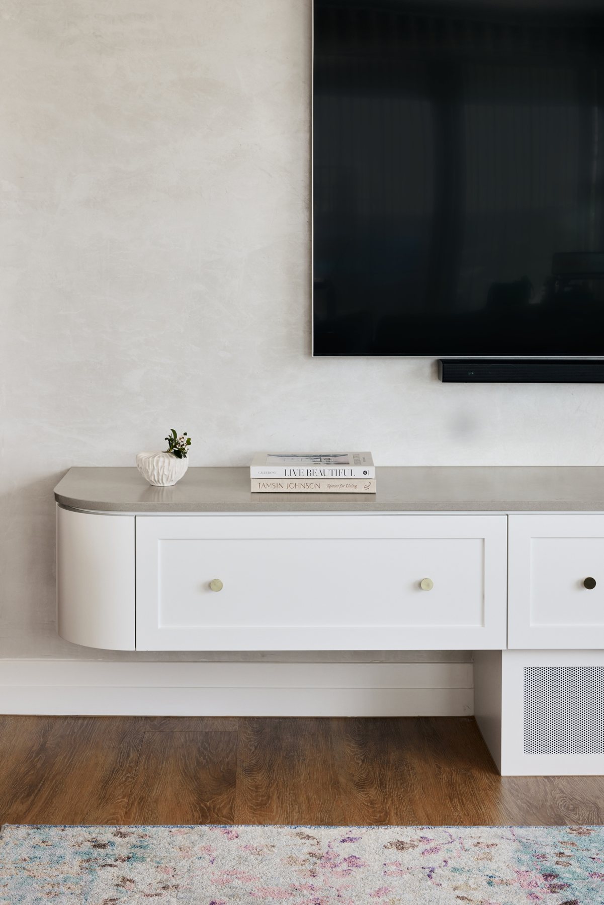Wall-mounted TV and soundbar above a floating cabinet