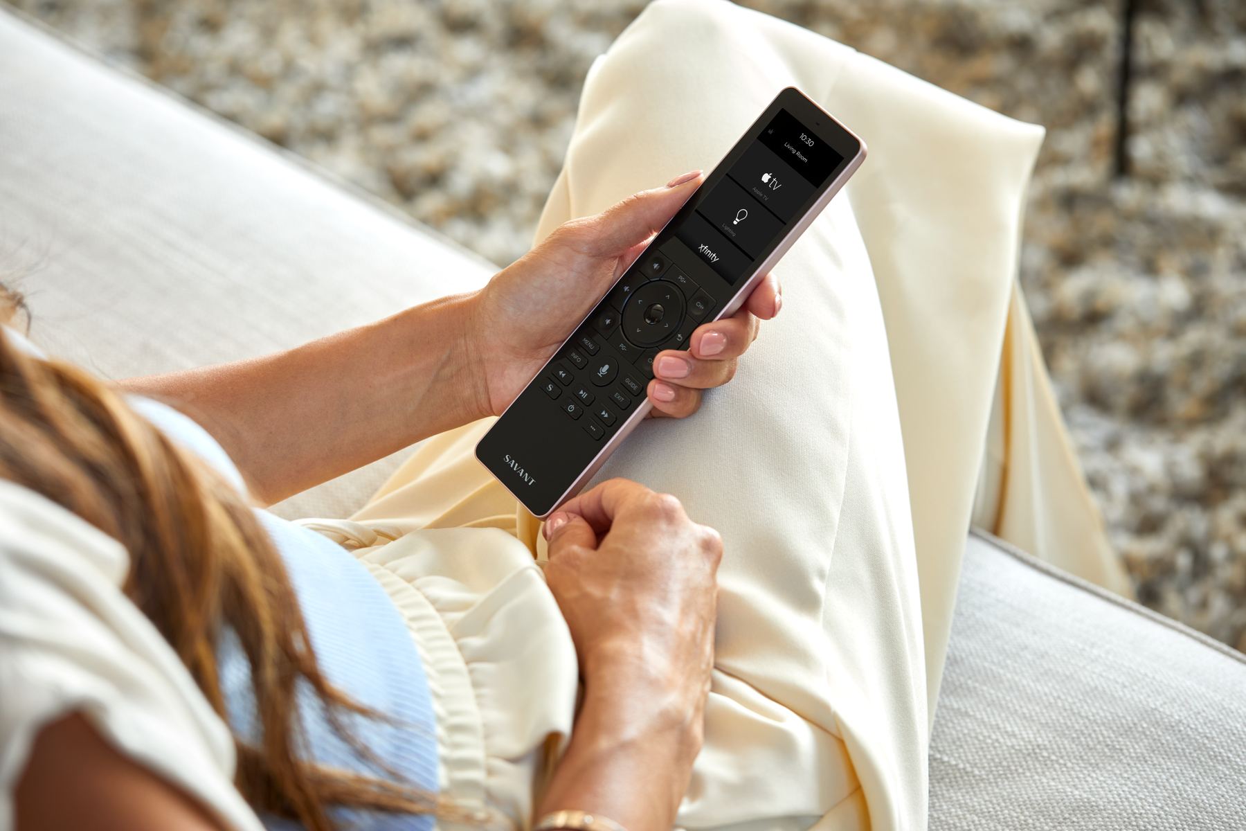 Savant Pro remote in hand on the couch