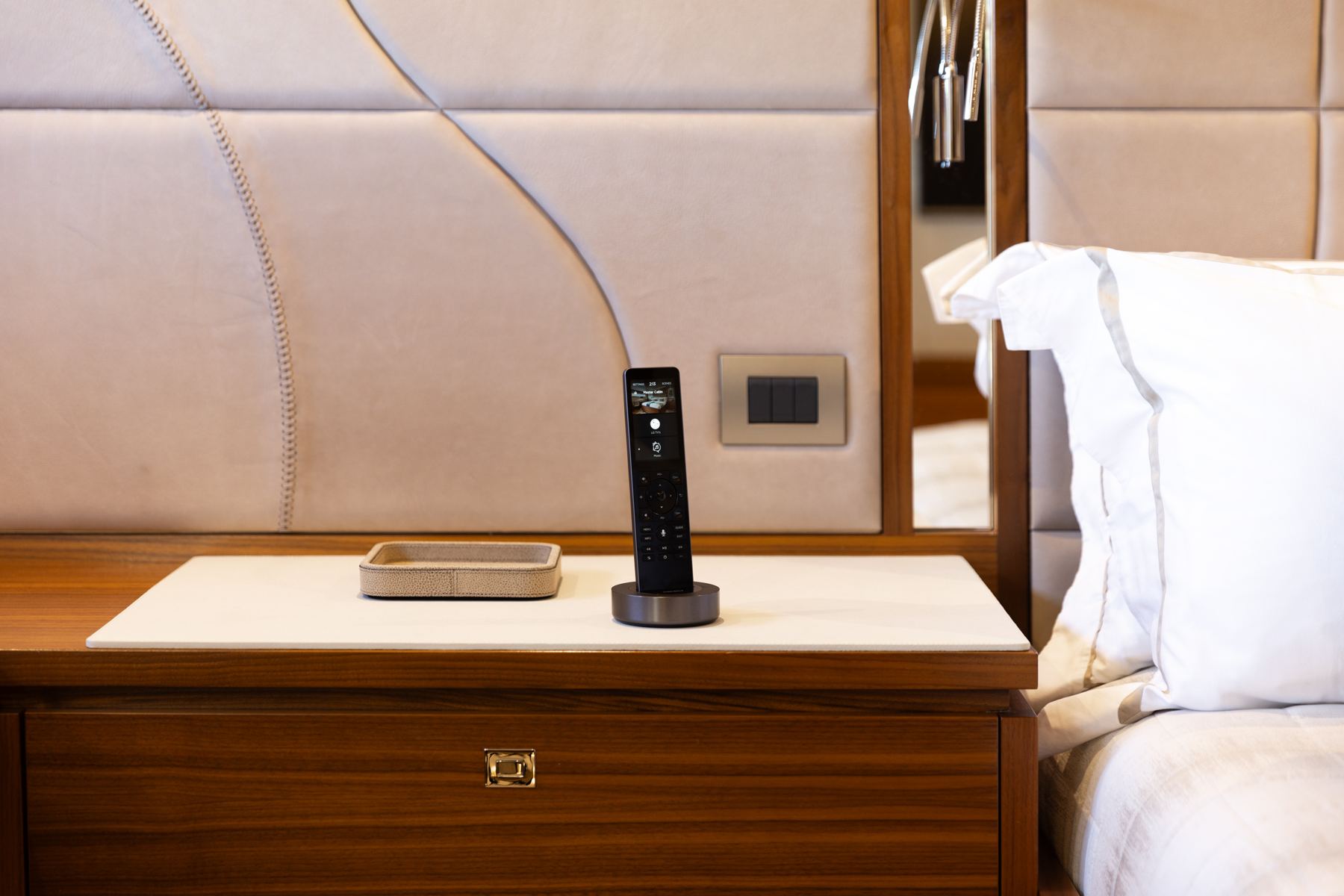 Savant Pro remote docked on a bedside table