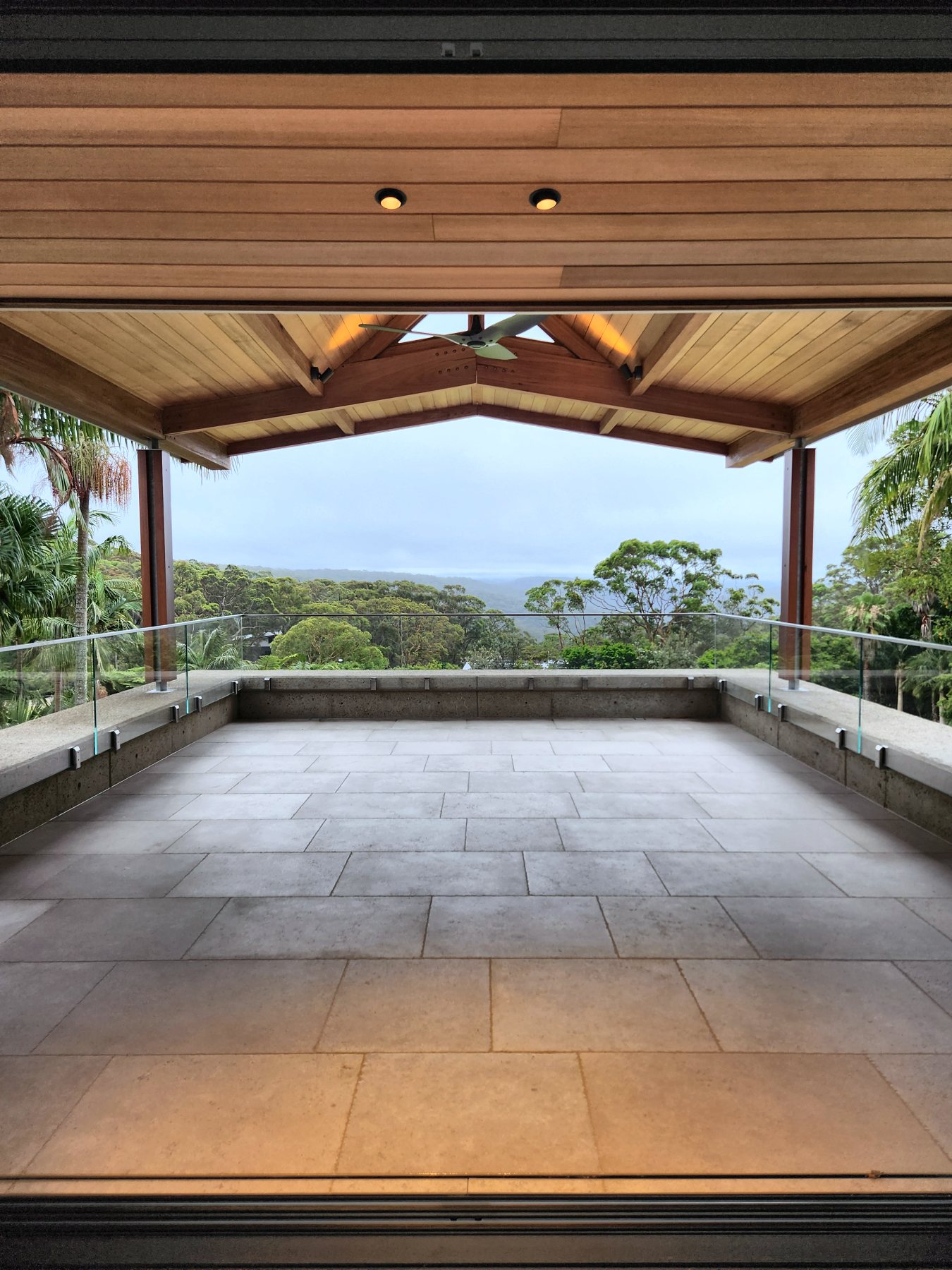 Alfresco terrace under a timber gable looking over the bush
