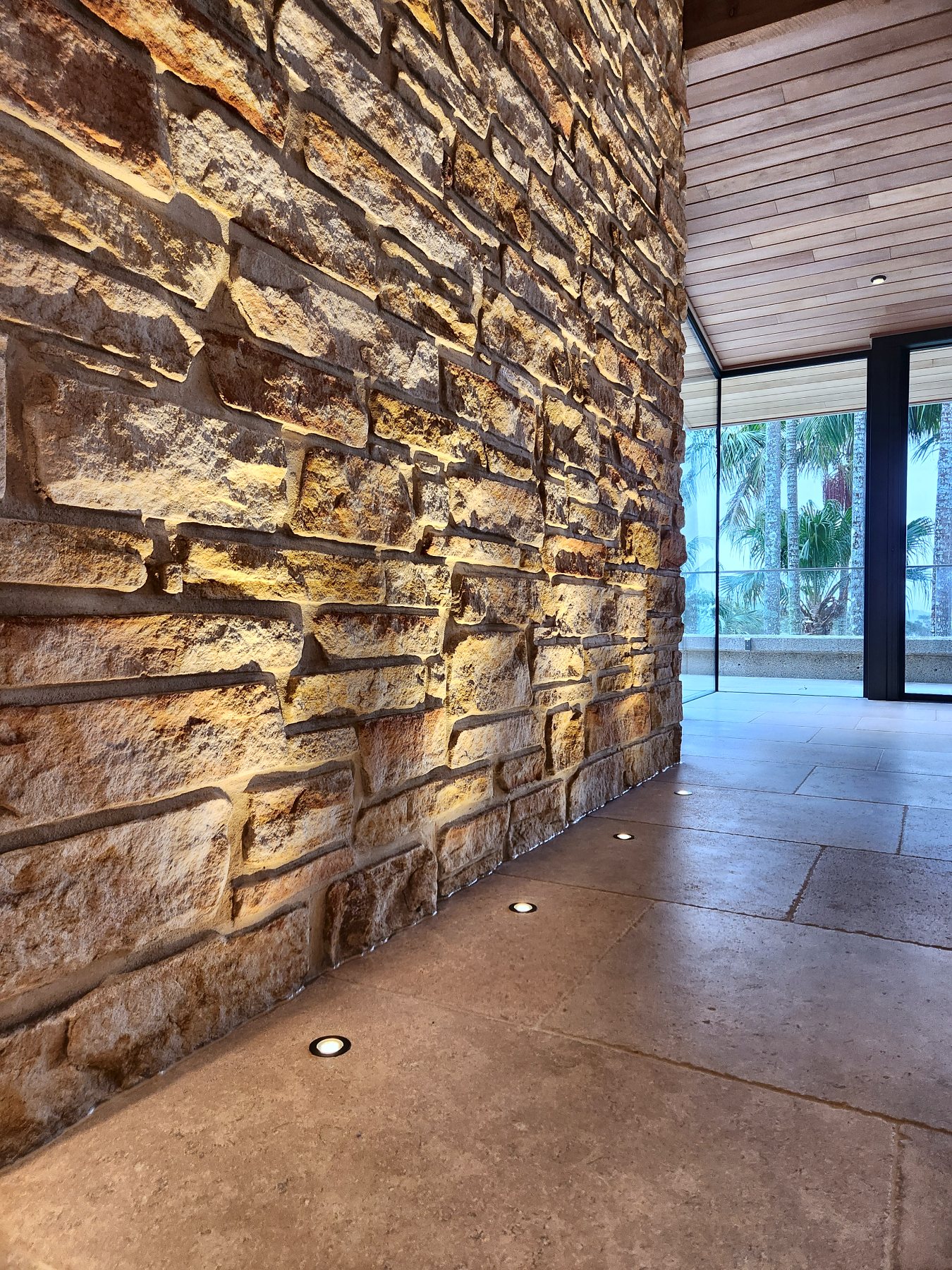 Sandstone wall lit by a row of in-floor uplights