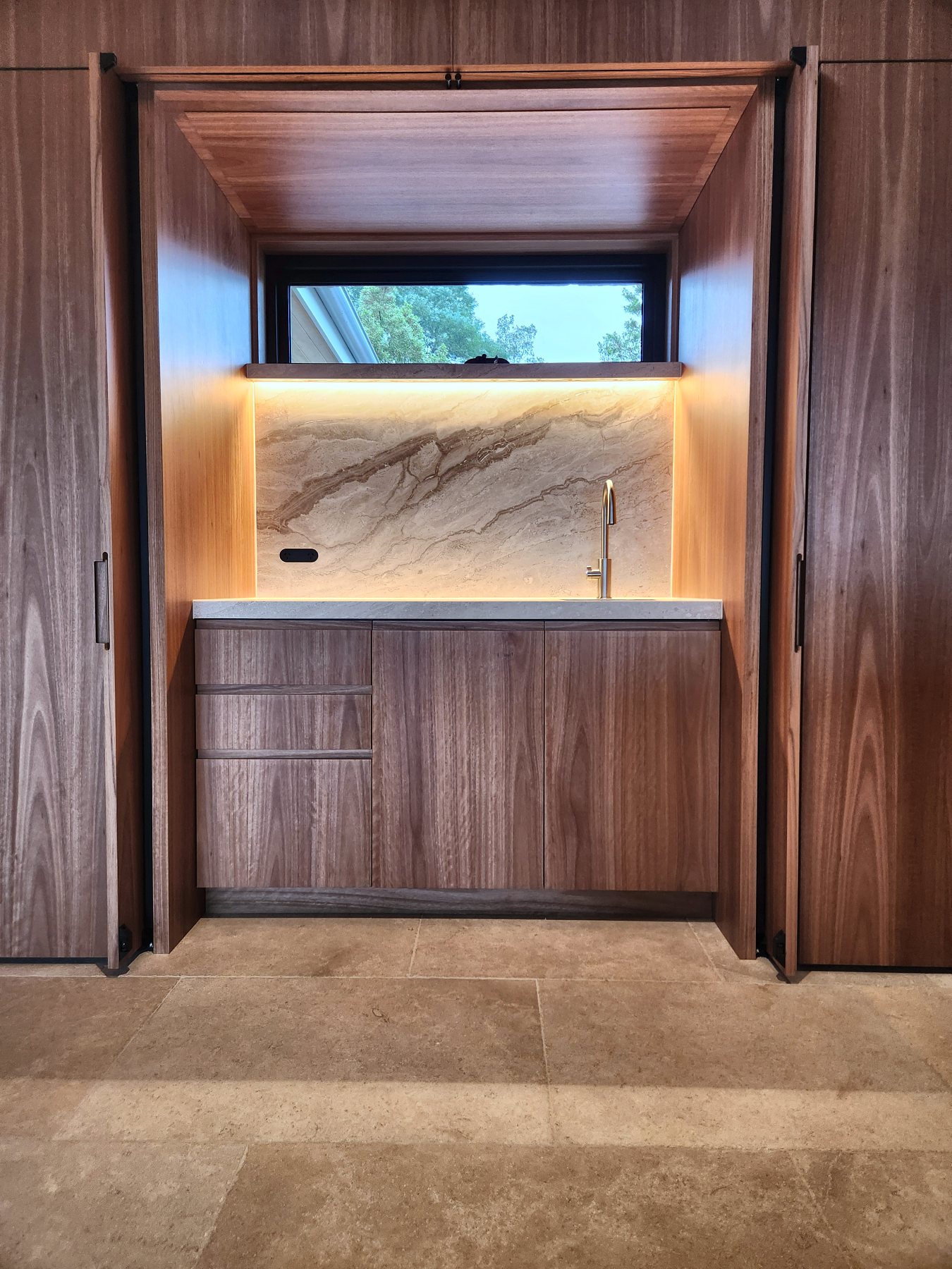 Walnut bar with LED behind a marble splashback